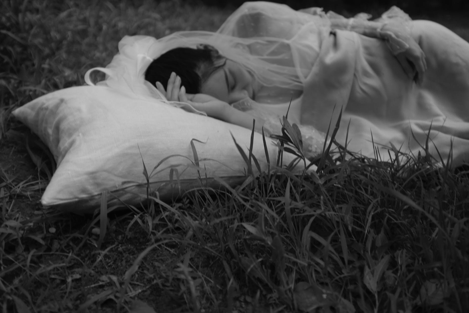 monochrome photo of woman sleeping on ground